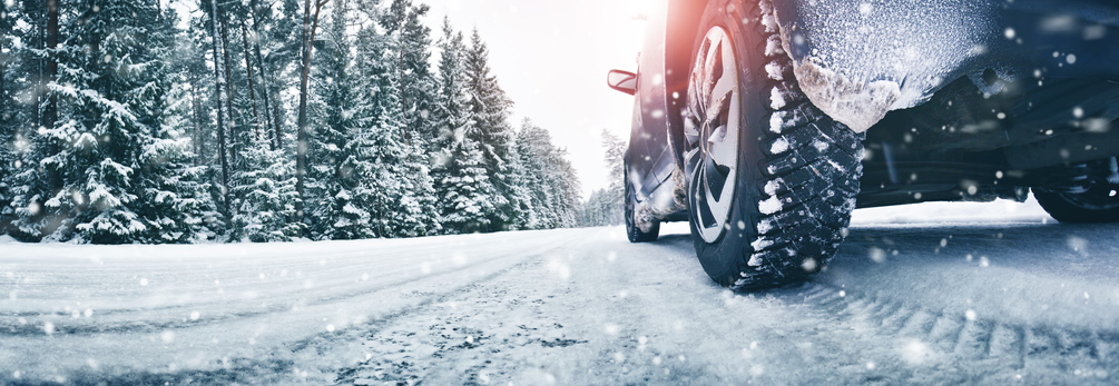 Closeup of car tires in winter on the road covered with snow