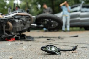 Damaged motorbike and car on the city road at the scene of an accident. Broken and wrecked motorcycle on road