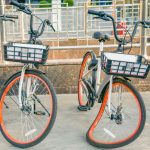 Street bikes in the parking lot. One of the bicycles has a bent front wheel. Bicycle rental outdoors. Bike sharing in the city.